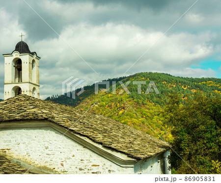 Old traditional Bulgarian church in mountain village of Kovachevitsa. Traditional slan stone roofs Old traditional Bulgarian church in mountain village of Kovachevitsa. Traditional slan stone roofs 86905831