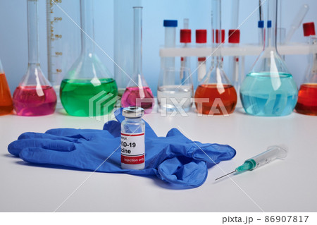 Coronavirus Vaccine and Glove on Chemical Desk Coronavirus Vaccine and Glove on Chemical Desk 86907817
