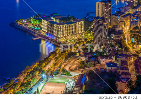Aerial view of Monaco - Monte-Carlo at dusk, cityscape with night illumination, mountain, skyscrapers, mediterranean sea Aerial view of Monaco - Monte-Carlo at dusk, cityscape with night illumination, mountain, skyscrapers, mediterranean sea 86908753