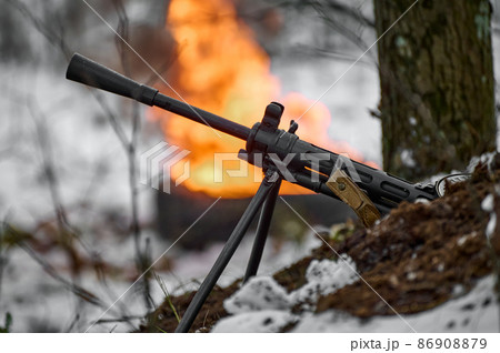 machine gun against the background of fire with a shallow depth of field 86908879