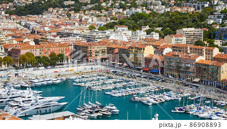 A lot o motor boats and luxury yachts are moored in port of Nice - France at sunny day, mooring ropes go into the amazing azure water, prows of motor boats in a row, roofs of orange color 86908893