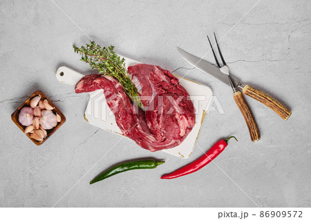 Raw beef whole tenderloin on concrete background Raw beef whole tenderloin on concrete background 86909572