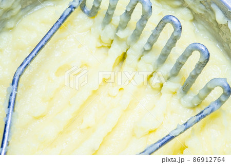 Selective focus on potato masher in fresh mashed potatoes. Selective focus on potato masher in fresh mashed potatoes. 86912764