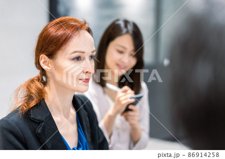 会議で発言する外国人女性と通訳の女性 会議で発言する外国人女性と通訳の女性 86914258