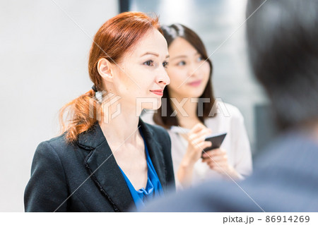 会議で発言する外国人女性と通訳の女性 会議で発言する外国人女性と通訳の女性 86914269
