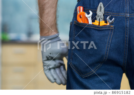 Close up shot of various plumbing hand tools in man's jeans back pocket Close up shot of various plumbing hand tools in man's jeans back pocket 86915182