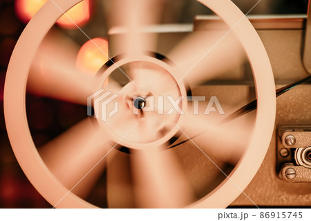 8mm movie projector playing at theater. White reel or can with tape film turning. Analog player 8mm movie projector playing at theater. White reel or can with tape film turning. Analog player 86915745