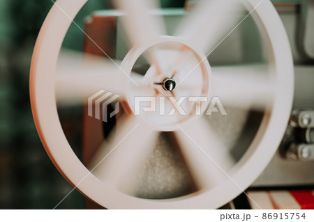 Coils with tape film turning. Analog player. Retro old-fashioned 8mm projector playing movie at Coils with tape film turning. Analog player. Retro old-fashioned 8mm projector playing movie at 86915754