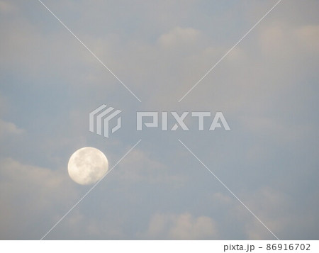 曇り空から垣間見える昼の白い朧月 曇り空から垣間見える昼の白い朧月 86916702
