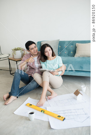 Close up of happy asian couple looking at blueprint at home Close up of happy asian couple looking at blueprint at home 86920150