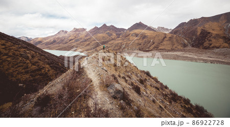 Woman backpacker hiking in winter plateau mountains Woman backpacker hiking in winter plateau mountains 86922728