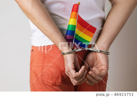 A man in handcuffs with an LGBT flag in his jeans pocket, a concept on the topic of violation of the rights of LGBT minorities and oppression in different countries 86923753