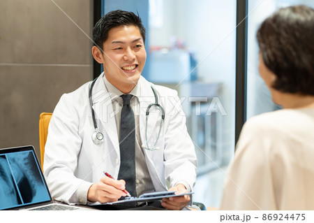 診察する若い医者と患者の女性　　撮影協力：WEEK芝大門(サンフロンティア不動産) 86924475