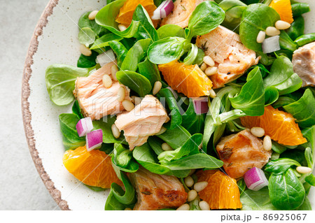 Salmon orange salad with pine nuts, red onion and corn salad. Top view 86925067