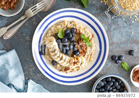 Oatmeal with fresh blueberries and pecans and banana 86925072