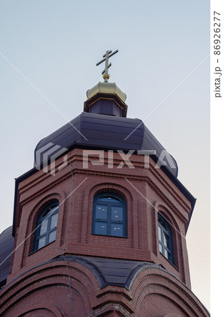 The building is the Modern Ukrainian Christian Orthodox Church. Redbrick building with golden domes against a clear blue sky. Religion, a symbol of faith. Christian Architecture. 86926277