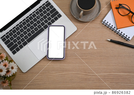 Smart phone, laptop computer, coffee cup and notebook on wooden background. 86926382