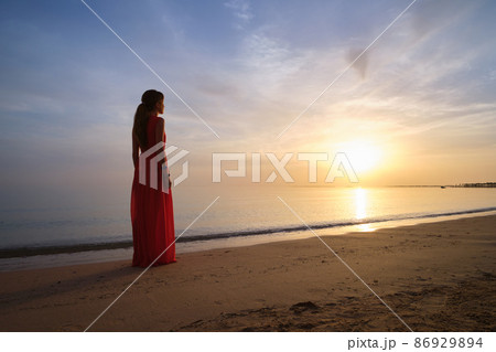 Young woman relaxing alone on ocean sand shore by seaside enjoying warm tropical evening. Young woman relaxing alone on ocean sand shore by seaside enjoying warm tropical evening. 86929894