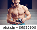 Old-fashioned camera in the hands of a muscular young cameraman 86930908