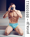 Old-fashioned camera in the hands of a muscular young cameraman 86930911