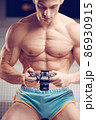 Old-fashioned camera in the hands of a muscular young cameraman 86930915