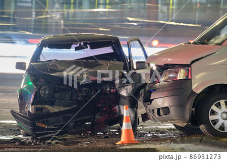 Damaged in heavy car accident vehicles after collision on city street crash site at night. Road safety and insurance concept 86931273
