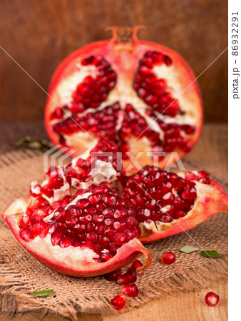 Juicy pomegranate and its half Beautiful composition with juicy pomegranates, on old wooden table 86932291