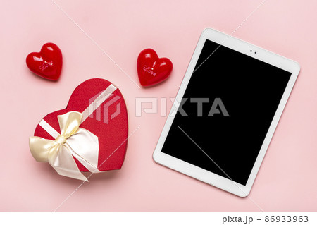 tablet for chooses gifts, makes purchase, envelope, box, two red hearts on pink table Top view Flat lay Holiday shopping list, Happy Valentine's day, party, online shop concept Mock up 86933963