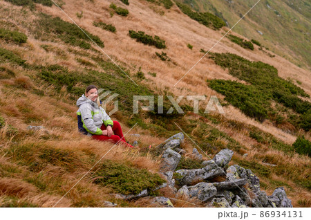 Carpathian hiking trails, female tourist admires Carpathian landscapes, autumn time in the mountains. Carpathian hiking trails, female tourist admires Carpathian landscapes, autumn time in the mountains. 86934131