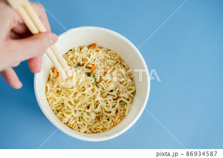 instant noodles with wooden chopsticks on a blue background, top view. Korean national dish. 86934587