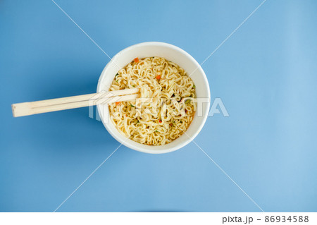 instant noodles with wooden chopsticks on a blue background, top view. Korean national dish. 86934588