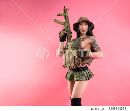 sexy brunette girl in military clothes and body armor with weapons 86936843