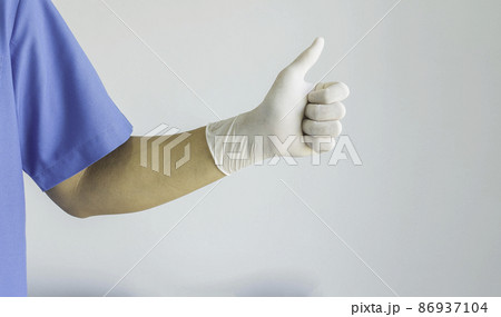 Doctor wearing a blue uniform and rubber gloves and thumbs up. On white background.. Doctor wearing a blue uniform and rubber gloves and thumbs up. On white background.. 86937104