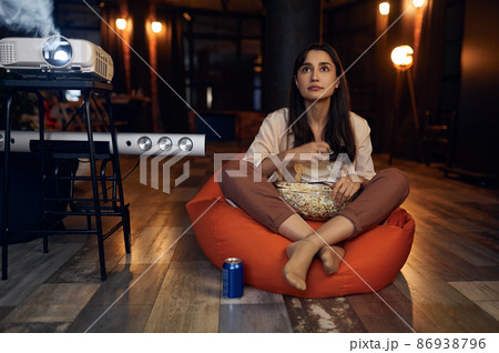 Young woman watching horror film video Young woman watching horror film video 86938796