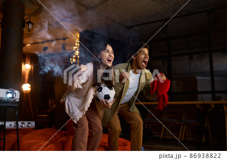Couple watching football match on home projector 86938822