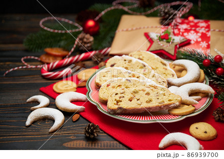 Slices of Traditional Christmas stollen cake with marzipan and New Year decorations Slices of Traditional Christmas stollen cake with marzipan and New Year decorations 86939700