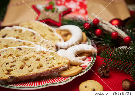 Slices of Traditional Christmas stollen cake with marzipan and New Year decorations Slices of Traditional Christmas stollen cake with marzipan and New Year decorations 86939702