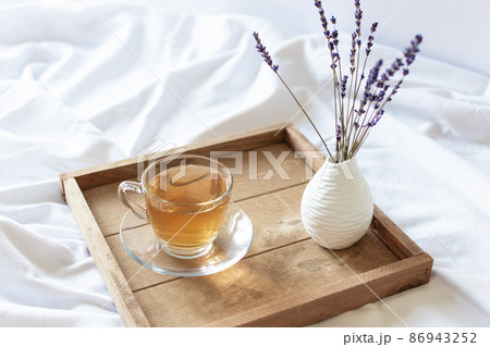 A cup of tea in the morning on wooden tray in bed. 86943252