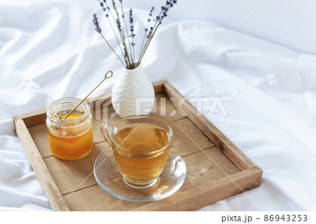 A cup of tea in the morning on wooden tray in bed. A cup of tea in the morning on wooden tray in bed. 86943253