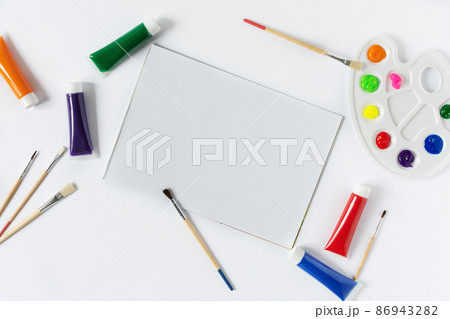 Pain brushes, watercolours and paint palette top view with blank sketchbook on white background. 86943282
