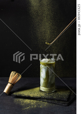 Japanese iced matcha latte and matcha tools on black background. 86943325