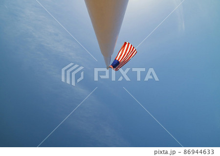 Looking up the America flag swinging on a pole 86944633