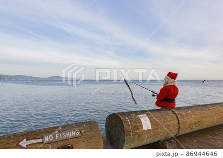Close up shot of Santa fishing at the shore of Santa Barbara Close up shot of Santa fishing at the shore of Santa Barbara 86944646