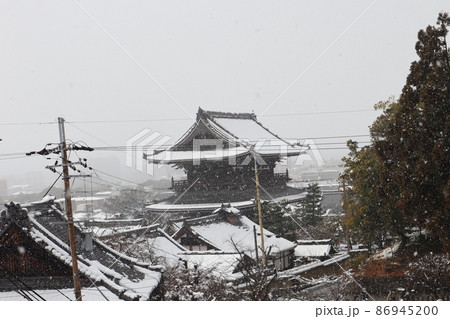 冬空から雪が降り積もる山門の見える京都の街の冬の雪景色の風景 冬空から雪が降り積もる山門の見える京都の街の冬の雪景色の風景 86945200