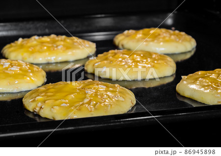 Cooking many homemade crunchy oatmeal cookies on metal sheet in oven Cooking many homemade crunchy oatmeal cookies on metal sheet in oven 86945898