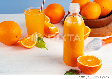 Bottle of orange juice and fresh oranges on table Bottle of orange juice and fresh oranges on table 86945925