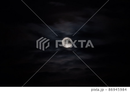 Moon rising against black sky with clouds at night 86945984