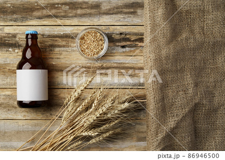 A bottle of beer and grain. Top view. Free space for text. A bottle of beer and grain. Top view. Free space for text. 86946500