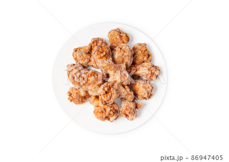 Frozen semi-cooked chicken wings on a white plate on a white background.Fast food, convenience food. Frozen semi-cooked chicken wings on a white plate on a white background.Fast food, convenience food. 86947405