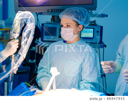 Professional female doctor in a mask and uniform in the operating room. Professional female doctor in a mask and uniform in the operating room. 86947935